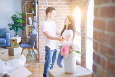 Karton kutular etrafında yeni evde dans genç güzel çift