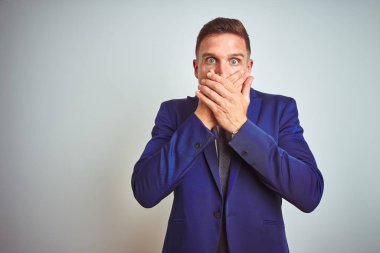 Beyaz izole arka plan üzerinde genç yakışıklı iş adamı hata için elleri ile ağız kapsayan şok. Gizli kavram.