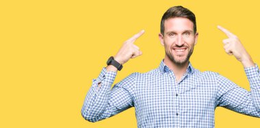 Mavi gözlü yakışıklı iş adamı Gülümseyen iki eliyle parmak, harika bir fikir ya da düşünce, iyi bellek ile baş işaret