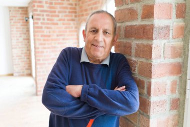 Yakışıklı orta yaş kıdemli neşeli, mutlu gülümseyen adam ve yerine koymak