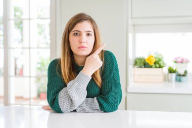 Genç güzel artı beden kadın rahat çizgili kazak giyen yan reklam gösteren el parmağı ile işaret, ciddi ve sakin yüz