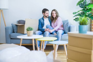 Genç çift içinde aşk sarılma oturma üzerinde the kanepe çok mutlu Moving için bir yeni ev