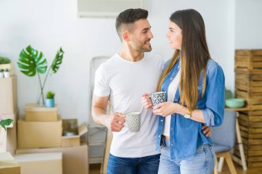 Güzel çift yeni bir eve hareketli, neşeli bir fincan kahve içme gülümseyen