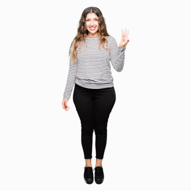 Genç güzel kadın çizgili kazak gösteren giyen ve parmak sayısı üç ile işaret kadar güven ve mutlu gülümseyen.