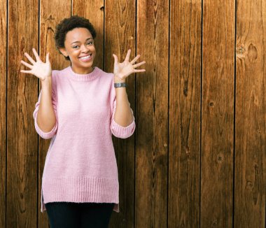 Gösterilen ve parmakları ile işaret izole arka plan güzel genç Afro-Amerikan kadın kendinden emin ve mutlu gülümseyerek süre on numara.