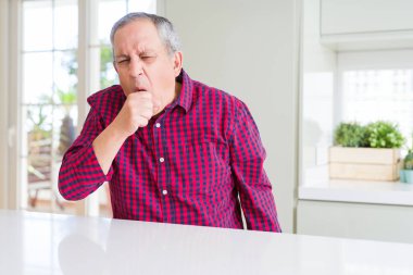 Evde yakışıklı yaşlı adam kötü duygu ve soğuk veya bronşit için belirti olarak öksürük. Sağlık kavramı.