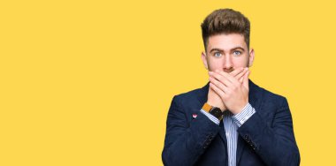 Genç yakışıklı bussines adam ağız hata için elleriyle kapsayan şok. Gizli kavramı.
