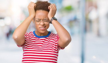 Güzel genç Afro-Amerikan kadın gözlük çünkü umutsuz ve stresli baş ağrısı acı izole arka plan üzerinde ağrı ve migren. Ellerini kafasına.