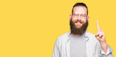 Gösterilen ve kendinden emin ve mutlu gülümseyen bir parmak ile işaret eden oktan yukarı gözlüklü genç sarışın adam.