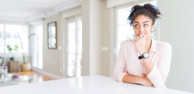 Afro saçlı güzel afro-amerikan kadın geniş açı düşünme bir soru hakkında endişeli, endişeli ve çene üzerinde el ile sinirli