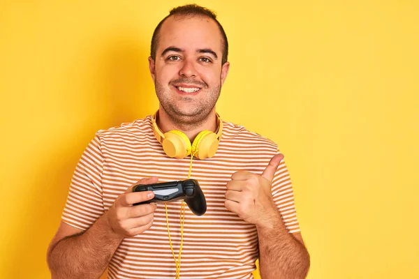 기호를하고 미소행복 노란색 배경을 헤드폰을 사용하여 비디오 게임을 게이머 손가락으로 — 스톡 사진