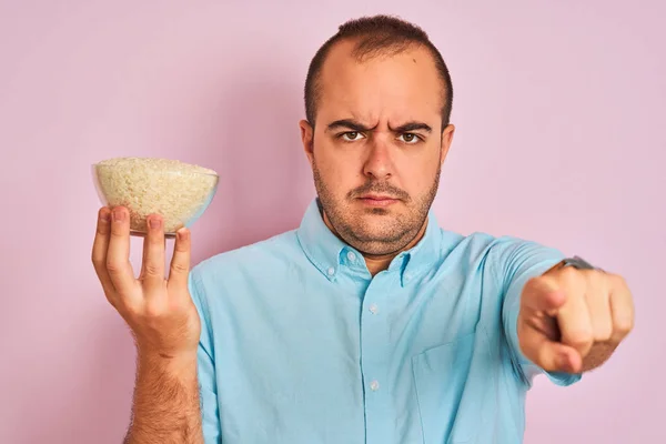 Joven Sosteniendo Tazón Con Arroz Pie Sobre Fondo Rosa Aislado —  Fotos de Stock