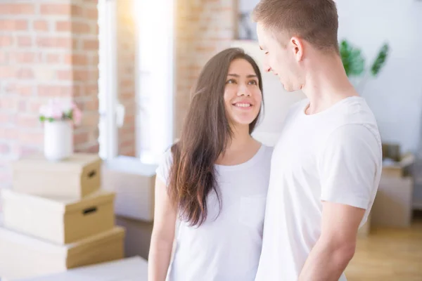 stock image Young beautiful couple standing at new home around cardboard boxes