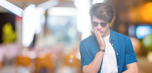 Jonge Knappe Man Dragen Van Een Zonnebril Geïsoleerde Achtergrond Denken — Stockfoto