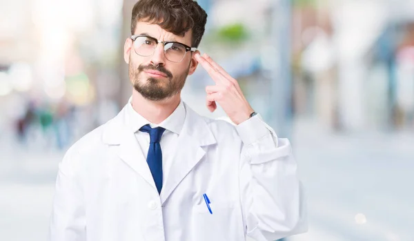 年轻的专业科学家男子穿着白色外套在孤立的背景拍摄和杀死自己指着手和手指头 自杀手势 — 图库照片