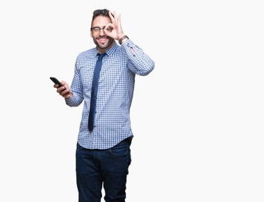 Mutlu yüz el parmaklarının arasından seyir göz üzerinde ok işaretiyle yapıyor gülümseyen izole arka plan üzerinde Smartphone kullanarak genç iş adamı