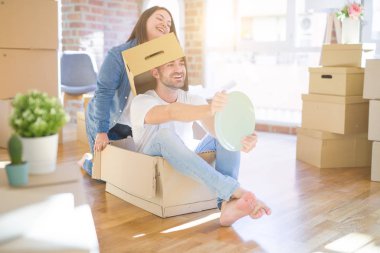 Komik ve çılgın çift bir araba olarak bir cardboad kutusu sürme eğlenceli sahip, mutlu gülümseyen ve yeni evde gülüyorsun