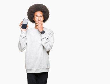 Smartphone ekran ciddi bir yüz düşünme hakkında soru, çok karışık fikir gösterilen afro saçlı genç Afro-Amerikan adam