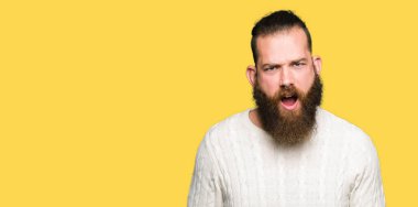 Şok karşısında, kış kazak giyen genç hipster adam şüpheci ve alaycı, bakan açık ağız ile şaşırttı