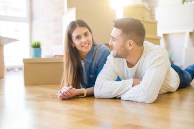 Yeni evin katında yatan genç güzel çift, yeni daireye taşınmak için çok mutlu aşk gülümsüyor