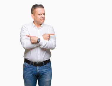 Orta yaş Arap zarif adam izole arka plan üzerinde işaretleme için her iki parmak, farklı yönde ile katılmıyorum