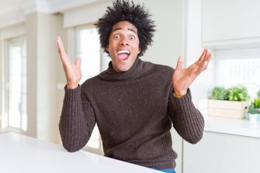 Afrika kökenli Amerikalı adam kış kazak deli ve silah ile başarı için hayran kutluyor giyen kaldırdı ve açık gözleri çığlık heyecanlı. Kazanan kavramı