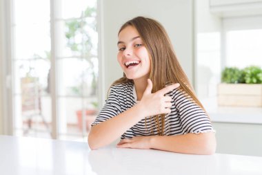 Güzel genç kız çocuk çizgili t-shirt neşeli bir yüz yüzü ile işaret eden bir gülümseme ile neşeli yan yana mutlu ve doğal ifade ile