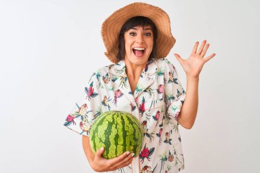 Yazlık şapka giyen kadın izole beyaz arka plan üzerinde karpuz tutan çok mutlu ve heyecanlı, kazanan ifade büyük bir gülümseme ile çığlık zafer kutluyor ve ellerini kaldırdı