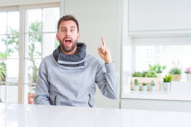 Yakışıklı adam evde parmak ile başarılı fikir işaret. Çıktıktan ve mutlu. Bir numara.