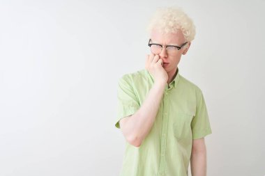 Genç albino sarışın adam yeşil gömlek ve gözlük izole beyaz arka plan üzerinde görünümlü stresli ve ağız tırnak ısırma elleri ile sinir giyiyor. Anksiyete sorunu.