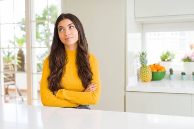 Beyaz masada evde genç güzel kadın yan bakıyor ve düşünme uzağa bakıyor.