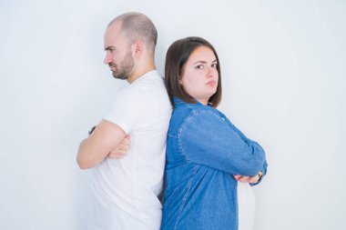 Beyaz izole arka plan şüpheci ve sinir üzerinde birlikte genç çift, çapraz kolları ile yüzünde onaylamayan ifade. Negatif kişi.
