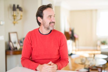 Yakışıklı orta yaş erkek evde doğal yüz emin gülümseme ile pozuyla profil rahatla tarafına, seyir.