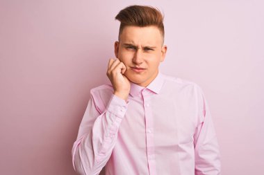 Genç yakışıklı işadamı dişler üzerinde diş ağrısı veya diş hastalığı nedeniyle ağrılı ifade ile el ile ağız dokunmadan izole pembe arka plan üzerinde duran zarif gömlek giyiyor. Diş hekimi konsepti.