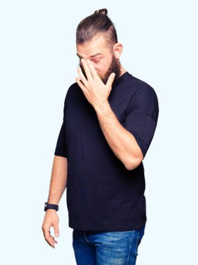 Rahat t-shirt yorgun sürtünme burun ve gözleri hissi yorgunluk ve baş ağrısı giyen genç sarışın adam. Stres ve hayal kırıklığı kavramı.