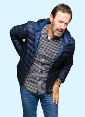 Orta yaş yakışıklı adam giyen kış ceket acı dokunmadan el ile geri, kas ağrısı, sırt ağrısı,