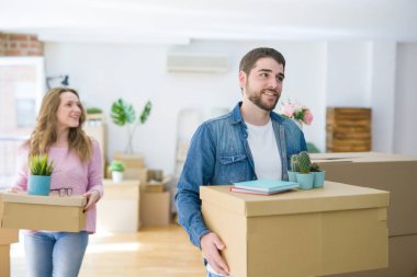 Yeni bir ev taşımak karton kutular tutarak birlikte çok mutlu genç güzel çift
