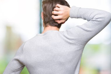 İzole arka plan geriye düşünme hakkında şüphe ile baş taraftan üzerinde kış kazak giyen genç yakışıklı adam