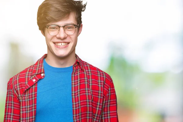 Young handsome student man wearing glasses over isolated background with a happy and cool smile on face. Lucky person.