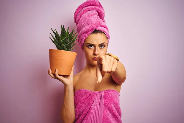 シャワーの後にタオルを着用する美しい女性は カメラに指で指で指を指して 前面からポジティブで自信のあるジェスチャーを指してサボテンの上にサボテンを保持 — ストック写真