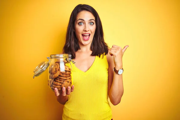 Jovem Mulher Bonita Segurando Frasco Biscoitos Sobre Fundo Isolado Amarelo — Fotografia de Stock