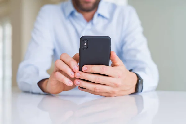 Az ember kezét használ smartphone és mosolyogva közelről — Stock Fotó