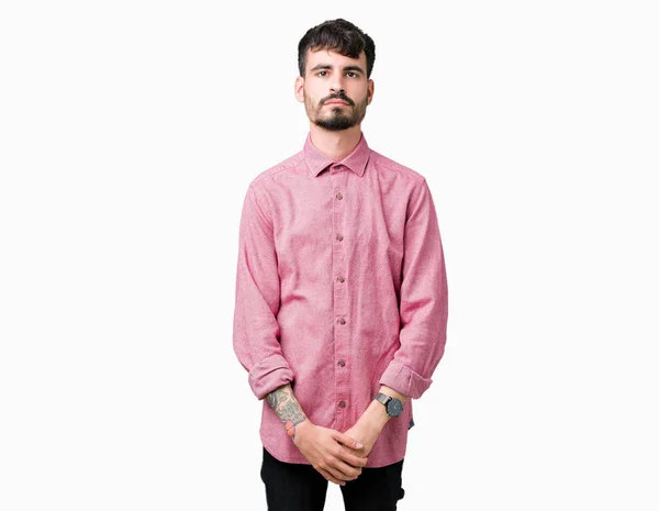 若いハンサムな男の顔に真剣な表情で孤立した背景リラックスにピンクのシャツを着てします シンプルで自然なカメラを見てください — ストック写真