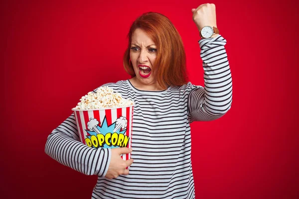 Joven Mujer Pelirroja Hermosa Comiendo Palomitas Maíz Sobre Fondo Rojo —  Fotos de Stock