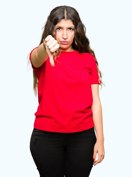 カジュアルなTシャツを着た若い美しい女性は 親指ダウンジェスチャーで拒絶と否定的な表示不幸と怒りを見て 不適切な式 — ストック写真