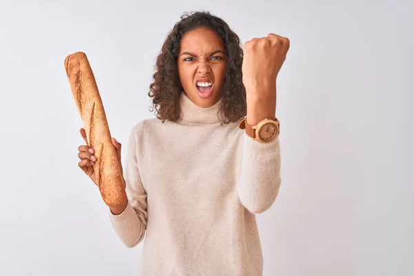 孤立した白い背景の上に立つパンを持つ若いブラジルのパン屋の女性は 狂気と叫び声で怒りとイライラし 上げられた手 怒りの概念で叫ぶ — ストック写真