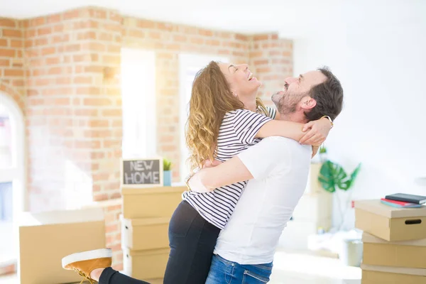 Middle age senior couple moving to a new house, smiling happy in love with apartmant