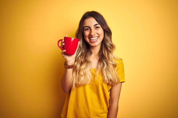 Młoda Piękna Kobieta Trzyma Czerwoną Filiżankę Kawy Żółtym Białym Tle — Zdjęcie stockowe