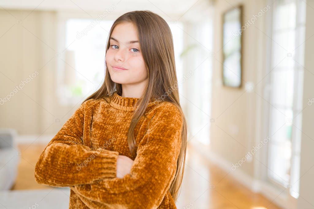 Beautiful young girl kid at home Relaxed with serious expression on face. Simple and natural with crossed arms