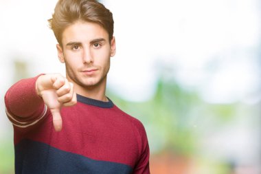 Yakışıklı delikanlı mutsuz ve kızgın ret gösterilen ve başparmak aşağı hareketi ile negatif seyir izole arka plan üzerinde. Kötü ifade.